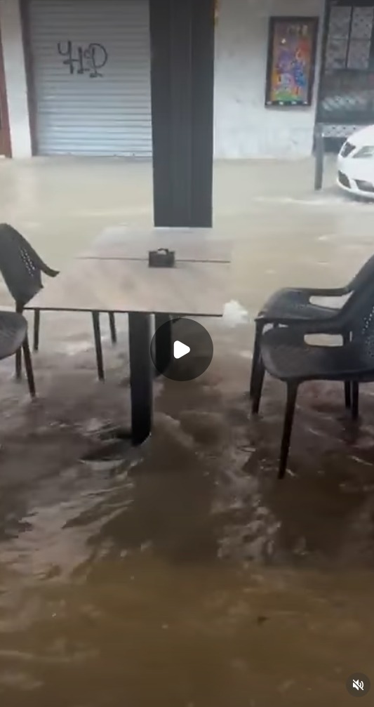 Floodwater reaching a street-level terrace after torrential rain